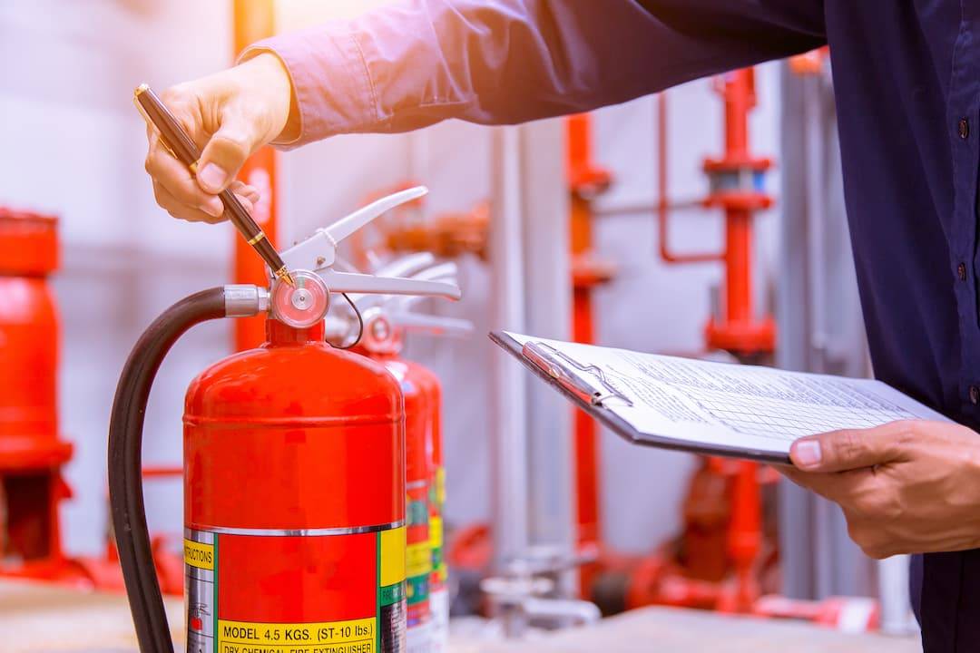 Man inspecting fire extinguisher