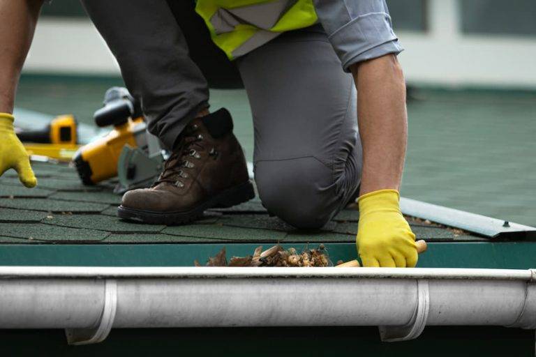 Man cleaning a gutter